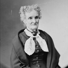 Black and white photograph of an older woman in early 1800s dress