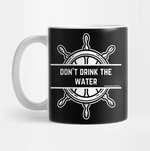 A black mug with a white handle and a white ship's wheel. Across the center of the wheel it says Don't Drink the Water
